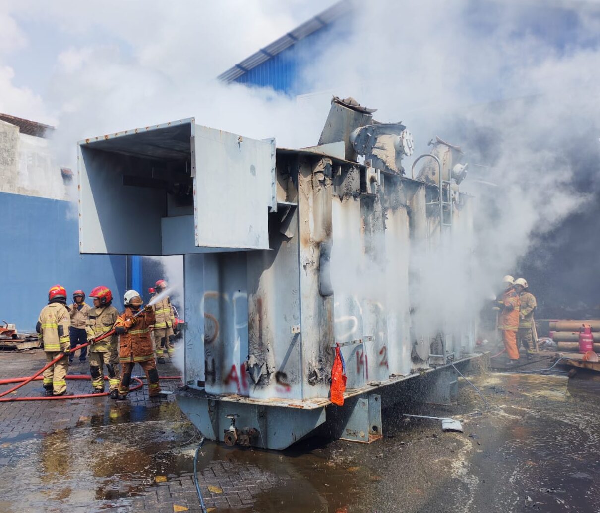 Trafo rusak yang akan dijadikan besi tua terbakar dan membuat warga pani, petugas berusaha memadamkan api dari trafo yang berukuran besar.